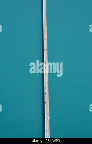 LUFTAUFNAHME. Gerade Straße auf einem Turquose See. Autobahn 94 nördlich von Savines-le-Lac, Lake Serre-Ponçon, Hautes-Alpes, Frankreich. Stockfoto