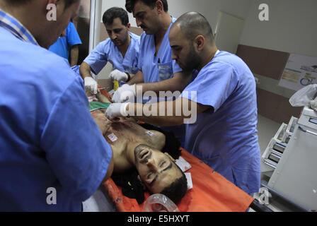 Ramallah, Westjordanland, Palästinensische Gebiete. 1. August 2014. Sanitäter versammeln sich um den Körper des jungen palästinensischen Udai Nafez auf 1. August 2014 am Klinikum der West Bank Stadt Ramallah, wo Udai starb, nachdem er in der Brust bei einem Zusammenstoß mit der israelischen Streitkräfte in Saffa, einem Dorf westlich von Ramallah erschossen worden war. Ein Sprecher des Roten Halbmonds sagte AFP, dass 73 Palästinenser von scharfer Munition und Gummigeschosse abgefeuert durch die israelischen Streitkräfte während der Freitag Auseinandersetzungen in der West Bank verletzt wurden, unter anderem in den Städten von Bethlehem und Hebron und in der Nähe von Ramallah Credit: ZUMA Press, Inc./Alamy Live News Stockfoto