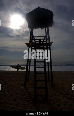 Silhouette einer Rettungsschwimmer stehen und Surfer zu Fuß in der Dämmerung Stockfoto