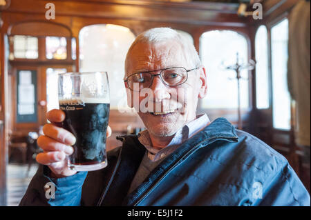 Älterer Mann trinken Pint Guinness in einem Pub, UK Stockfoto