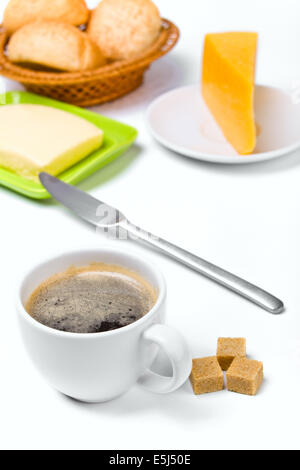 Tasse Kaffee mit braunem Zucker, Käse, Butter in eine grüne Butterdish und drei Brötchen Stockfoto