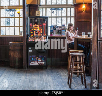 "Der Markt Porter" Innenraum - in einem traditionellen Londoner Pub mit Gaming-Maschine und Frau sitzen auf Barhocker - London, UK Stockfoto