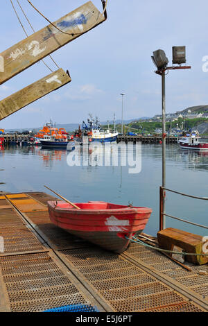 Eine rote Jolle auf eine rostige Slipanlage, Mallaig Werft, Schottland Stockfoto