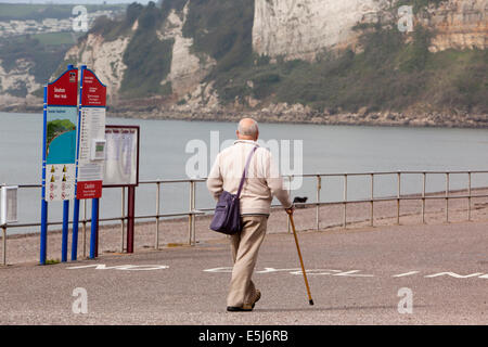 UK England, Dorset, Seaton Strand, älterer Mann zu Fuß mit Hilfe des Sticks entlang der Esplanade Stockfoto