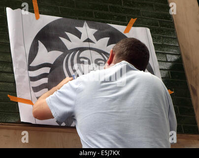 Signwriter arbeitet auf Logo für neue Starbucks Coffee Shop, London Stockfoto