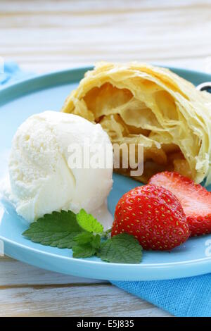 traditionelle Apfelstrudel mit Rosinen, serviert mit einer Kugel Eis Stockfoto