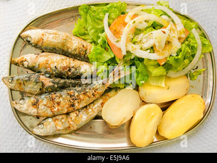 Gegrillte Sardinen mit mediterraner Salat und Salzkartoffeln. Typische mediterrane Gericht. Stockfoto