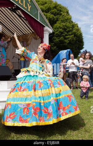 Eine Tänzerin aus der brasilianischen Gruppe, Maracatudo Mafua, unterhalten das Publikum auf hügeligen Feldern auf dem BrockleyMax Festival Stockfoto