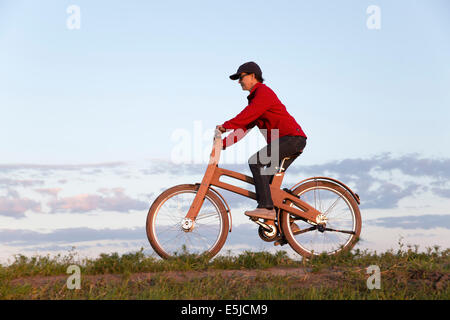 Niederlande, Stavoren, Frau mit dem Ast-Fahrrad. Das Dutch Design aus Holz-Bike ist eine Schöpfung von Jan Gunneweg Stockfoto