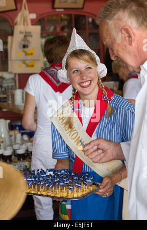 Niederlande, Edam, Käsemarkt, Mädchen in traditioneller Kleidung dient Stücke von Beemster Käse Stockfoto