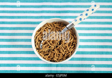 Gesunde Ernährung hohen Ballaststoff-Frühstück mit Schüssel mit Kleie Getreide auf Aqua blau-weißen Tischset. Stockfoto