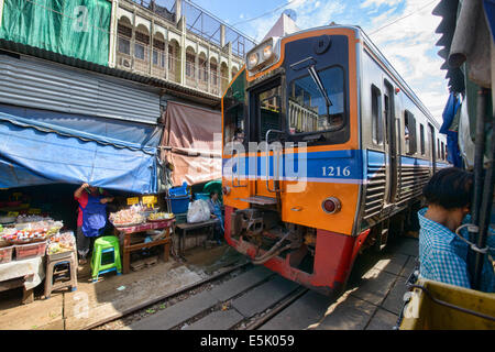 Die erstaunliche Mae Klong Eisenbahnmarkt (Talad Rom Hoop) wo Züge direkt durch einen Marktstand, Thailand fahren Stockfoto