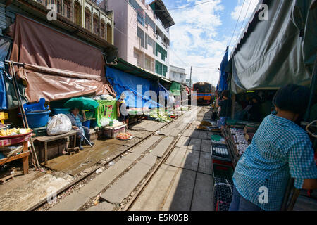 Die erstaunliche Mae Klong Eisenbahnmarkt (Talad Rom Hoop) wo Züge direkt durch einen Marktstand, Thailand fahren Stockfoto