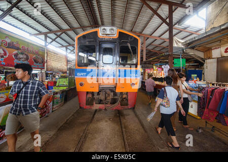 Die erstaunliche Mae Klong Eisenbahnmarkt (Talad Rom Hoop) wo Züge direkt durch einen Marktstand, Thailand fahren Stockfoto