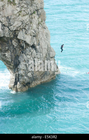 Durdle Door ist ein natürlicher Kalkstein Bogen an der Jurassic Coast in der Nähe von Lulworth in Dorset, England Leute abspringen Durdle Door Stockfoto