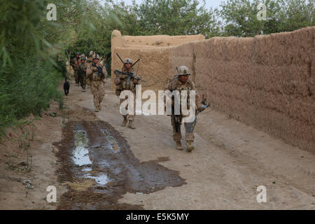 US-Marines mit dem 1. Bataillon, 7. Marineregiment patrouillieren entlang einer Wand Dorf während einer Mission 4. Juli 2014 in Gereshk, Provinz Helmand, Afghanistan. Stockfoto