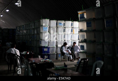 Kabul, Afghanistan. 3. August 2014. Afghanische Wahlbeobachter sitzen neben Wahlurnen vor der Zählung an einem Lagerort der unabhängigen Wahl Commission (IEC) in Kabul, Afghanistan, 3. August 2014. Die IEC am Sonntag fortgesetzt der Auditierung der Präsidentschaftswahl Stichwahl Wahl Stimmen nach vier Aufhängungen, da der Prozess am 17. Juli begann. © Ahmad Massoud/Xinhua/Alamy Live-Nachrichten Stockfoto