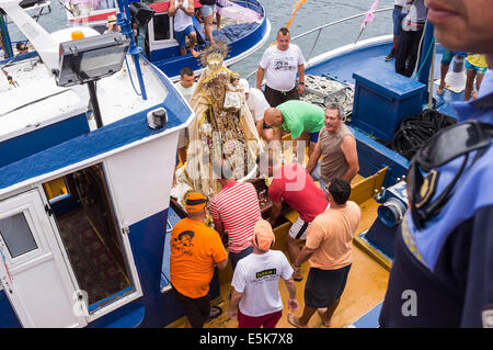 San Juan, Teneriffa, Kanarische Inseln, Spanien. 3. August 2014. Die Nuestra Señora del Carmen und San Juan Bautista Bildnissen werden in den Hafen gebracht und verladen auf Angelboote/Fischerboote für eine maritime Prozession, begleitet von einer Armada von Booten, um benachbarte Fischerdörfer im Rahmen des jährlichen Fiesta in Playa San Juan, Teneriffa, Kanarische Inseln, Spanien zu besuchen. Bildnachweis: Phil Crean A/Alamy Live-Nachrichten Stockfoto