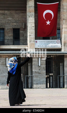 Berlin, Deutschland. 3. August 2014. Eine Frau mit Kopftuch nimmt eine "Selfie" vor dem Olympiastadion mit einer türkischen Fahne in Berlin, Deutschland, 3. August 2014. Erstmals können in den türkischen Präsidentschaftswahlen Zeit türkische Staatsangehörige in Deutschland teilnehmen. Foto: Paul Zinken/Dpa/Alamy Live News Stockfoto