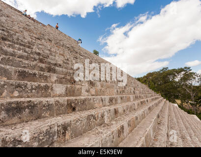 Ein Tourist nähert sich die Spitze der großen Pyramide von Uxmal. Ameise-wie ein Tourist steigt, während andere an der Spitze dieser Pyramide ruhen Stockfoto