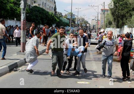 Rafah, Gaza-Streifen, Palästinensische Gebiete. 2. August 2014. Palästinensische Männer tragen einen verletzten Mann nach einem israelischen Militärschlag auf einer UN-Schule in Rafah im südlichen Gazastreifen am 3. August 2014. Mindestens 10 Menschen starben an einem frischen Streik auf einer UN-Schule im südlichen Gazastreifen die Palästinenser von einem israelischen Militäroffensive verdrängt bergende war, Sanitäter sagte Credit: Ashraf Amra/APA Bilder/ZUMA Draht/Alamy Live News Stockfoto