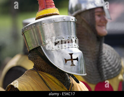 Beeston Castle, Cheshire, Großbritannien, 3. August 2014. Helmetrische bewaffnete Re-Enactors mit Schilden, beim Medieval Knights Tournament and Melee, einem Foot Soldier Combat Event. Historia Normannis, eine frühmittelalterlichen Kampfreenactment-Gruppe aus dem 12. Jahrhundert, erklärt die alte Kultur und Bräuche und stellt Ketten- und adrenalinbetriebene Reenactor Teams hochqualifizierter Ritter zur Verfügung, um mit Schwert-, Schild- und Vereinswaffen frontal zu kämpfen - eine Veranstaltung auf der English Heritage Site. Stockfoto