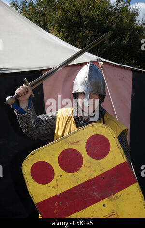 Beeston Castle, Cheshire, Großbritannien, 3. August 2014. Helmetrische bewaffnete Re-Enactors mit Schilden, beim Medieval Knights Tournament and Melee, einem Foot Soldier Combat Event. Historia Normannis, eine frühmittelalterlichen Kampfreenactment-Gruppe aus dem 12. Jahrhundert, erklärt die alte Kultur und Bräuche und stellt Ketten- und adrenalinbetriebene Reenactor Teams hochqualifizierter Ritter zur Verfügung, um mit Schwert-, Schild- und Vereinswaffen frontal zu kämpfen - eine Veranstaltung auf der English Heritage Site. Stockfoto