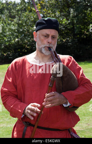 Beeston, Cheshire, UK 3. August 2014. Ein Musiker Piper an der mittelalterlichen Ritter Turnier in Beeston Castle in Cheshire, England. Historia Normannis ein 12. Jahrhundert frühes Mittelalter Reenactment Gruppe eine Veranstaltung auf dem English Heritage Site zur Verfügung gestellt. Stockfoto