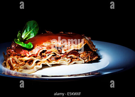 Lasagne mit Tomaten und Gemüse auf dunklem Hintergrund Stockfoto