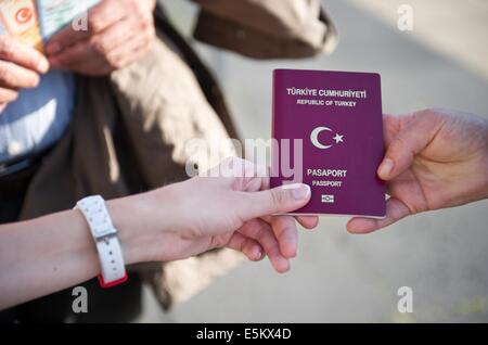 Berlin, Deutschland. 3. August 2014. Eine Frau zeigt ihren türkischen Pass im Olympiastadion in Berlin, Deutschland, 3. August 2014. Es gibt eine Wahl-Center für die türkischen Präsidentschaftswahlen im Olympiastadion in Berlin. Zum ersten können türkische Staatsangehörige, die Zeit in den türkischen Wahlen in Deutschland teilnehmen. Foto: Daniel Naupold/Dpa/Alamy Live News Stockfoto