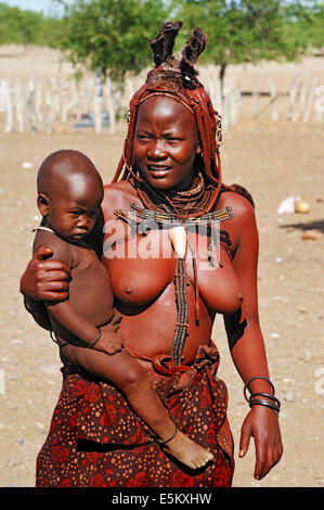 Frau mit Kind in einem Himba-Dorf in der Nähe von Opuwo, Namibia Stockfoto