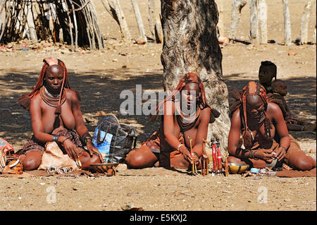 Frauen verkaufen Schnitzereien in einem Himba-Dorf in der Nähe von Opuwo, Namibia Stockfoto