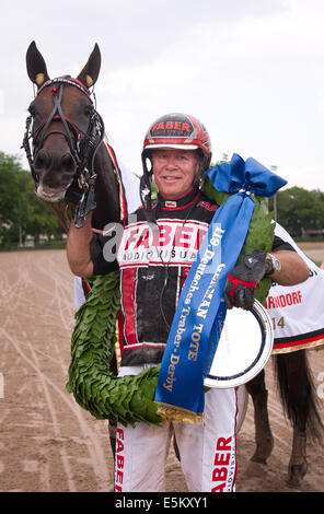 Berlin, Deutschland. 3. August 2014. Das Pferd Expo Express mit niederländischen Jockey Arnold Mollema gewinnt das 119. deutsche Trabrennen Rennen auf der Trabrennbahn in Berlin, Deutschland, 3. August 2014. Foto: Daniel Naupold/Dpa/Alamy Live News Stockfoto