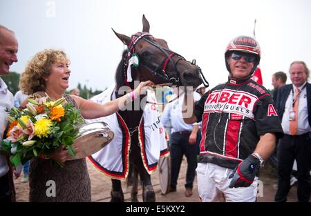 Berlin, Deutschland. 3. August 2014. Das Pferd Expo Express mit niederländischen Jockey Arnold Mollema (R) gewinnt das 119. deutsche Trabrennen Rennen auf der Trabrennbahn in Berlin, Deutschland, 3. August 2014. Foto: Daniel Naupold/Dpa/Alamy Live News Stockfoto