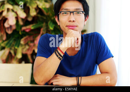 Glücklich asiatischen Mann mit Brille, die am Tisch sitzen Stockfoto