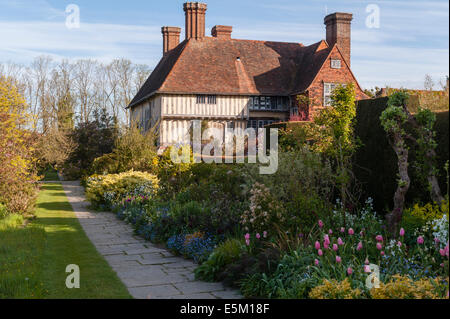 Great Dixter, East Sussex, Großbritannien, der berühmte Garten von Christopher Lloyd. Das Haus und die lange Grenze im Frühling Stockfoto
