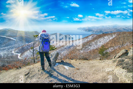 Frau trägt weiße Jacke Wanderungen auf dem Berg im winter Stockfoto