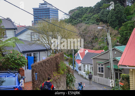 Wohnungsbau steile Lage in Wellington Neuseeland mit Mann und Kind zu Fuß die steile Straße hinunter. Stockfoto