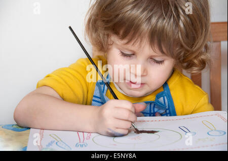 Niedliche kleine Mädchen malen in seinem album Stockfoto