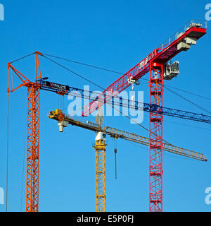 Drei Baukräne / Turmdrehkran gegen blauen Himmel Stockfoto