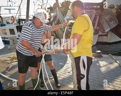 Fischer in Mallorca Spleißen ein Seil zusammen an der Hafen oder Hafen. Schließen sie sich alte und neue Seile um sie zu reparieren Stockfoto
