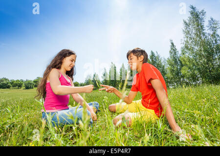 Kinder spielen auf dem Rasen Stein-Schere-Papier Stockfoto