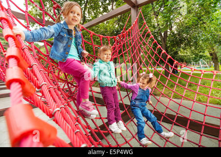 Drei kleine Mädchen sitzen auf roten Raster im Sommer Stockfoto