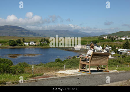 Eine einsame Frau saß auf einer Bank, bewundern Sie die Aussicht auf Bunessan, Isle of Mull, Schottland, Juli 2014 Stockfoto