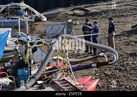 US Coast Guard Rear Admiral Dan Abel sieht handgemachte Ozean-gold Bagger am Strand von Nome Hafen während einer Vertrautheit Reise 2. August 2014 nach Nome, Alaska. Die willkürliche Boote sind auf der Reality-Show Bering Sea Gold gekennzeichnet. Stockfoto