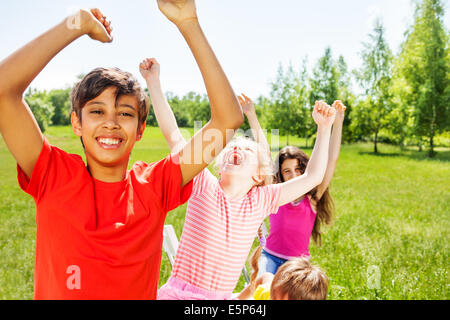 Glückliche Kinder mit Emotionen und Hände hoch im Sommer Stockfoto
