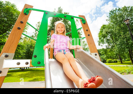 Reizendes Mädchen auf Spielplatz Rutsche bereit zu schieben Stockfoto