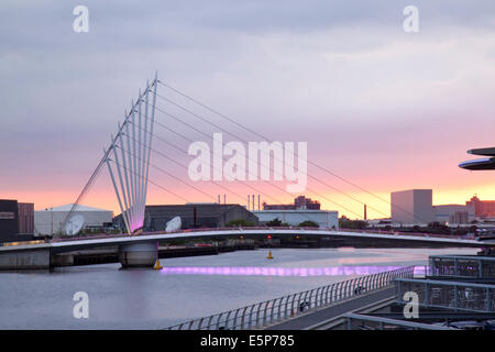 Media City Fußgängerbrücke in Salford Quays, Manchesterat Sonnenuntergang.  Eine asymmetrische Drehbrücke, designed by Gifford und Wilkinson Ayre Stockfoto