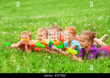 Kinder spielen mit Wasserpistolen Verlegung auf einer Wiese Stockfoto