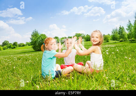 Drei Kinder spielen auf einer Wiese Stockfoto